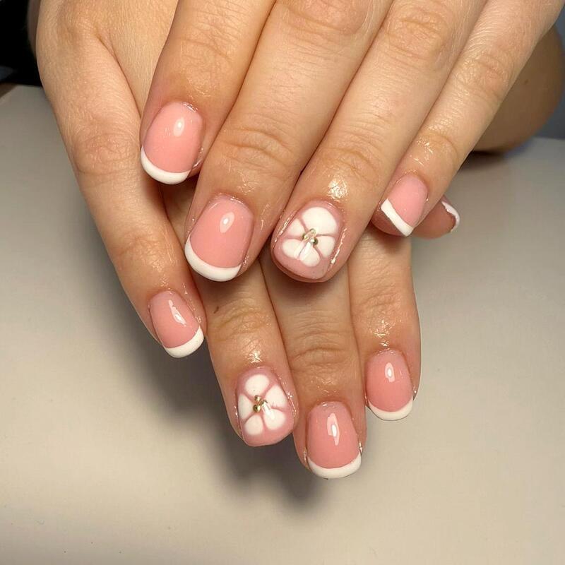 Pink nails with white French tips and white flowers